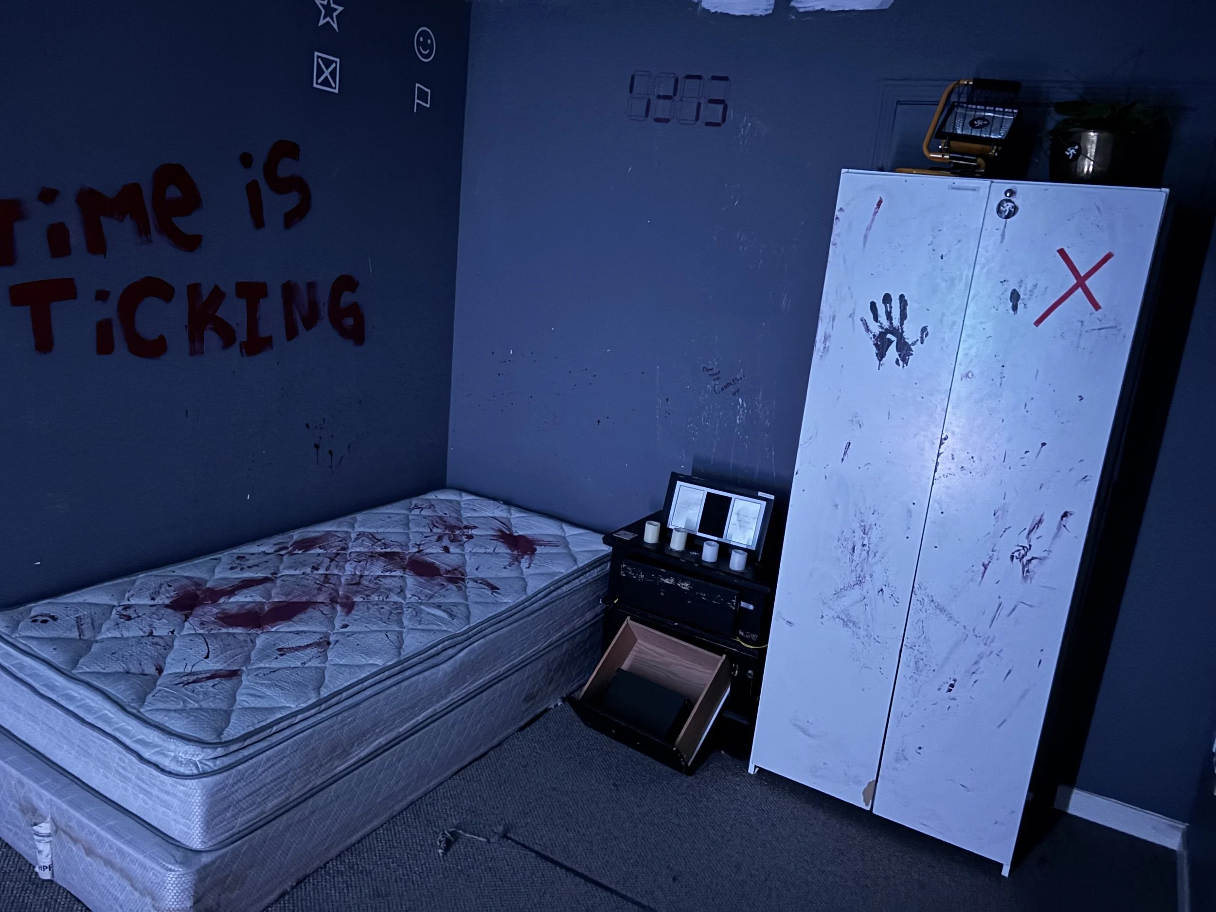 A dark room with cryptic red markings and a locked wardrobe